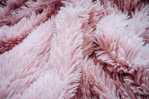 roze plaid met een lang stapel, de structuur van een zacht aangenaam sprei, haren opwarming met warmte, kleding stof structuur, vouwen van materiaal met stapel. foto