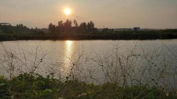 de zonsondergang kan worden gezien in de middag en u kan zien haar reflectie in de vijver water, de licht is werkelijk heel mooi foto