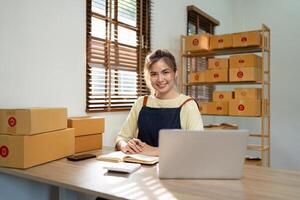 opstarten mkb klein bedrijf ondernemer mkb of freelance Aziatisch vrouw gebruik makend van een laptop met doos, jong succes Aziatisch vrouw online afzet pakketje doos en levering concept foto