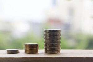 geld munt stack groeit Aan houten tafel Aan wazig achtergrond. foto