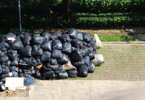 vuilnis in een zwart zak aan het wachten voor onderhoud vuilnis vrachtwagen. groot uitschot Tassen klaar voor vervoer. foto