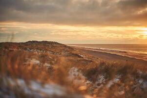 zonsondergang in winter Aan denemarken kust foto