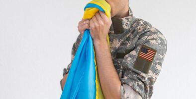 Amerikaans vlag Aan soldaten arm en vlag van de Oekraïne Bij achtergrond. ons leger ondersteuning Oekraïne foto