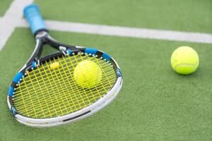 tennis racket en tennis bal Daarnaast de netto Aan buitenshuis tennis rechtbank. foto