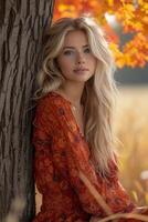 ai gegenereerd mooi blond vrouw in rood oranje jurk poseren door boom met kleurrijk bladeren foto