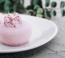 roze mousse cakes versierd Aan wit bord foto