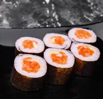 Zalm maki sushi Aan zwart steen bord foto