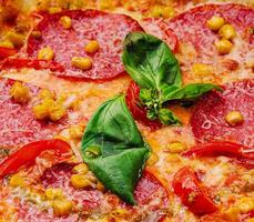 mooi en smakelijk peperoni pizza met maïs foto