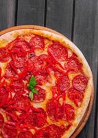 smakelijk peperoni pizza met rood klok peper foto