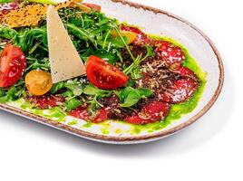 rundvlees carpaccio met Parmezaanse kaas en rucola Aan bord geïsoleerd foto