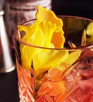 glas van negroni cocktail versierd met bloemen foto