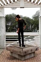 mager Aziatisch Amerikaans vrouw staand zwart broek foto