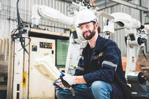 ingenieurs team monteur gebruik makend van computer controleur robot arm voor lassen staal in staal fabriek werkplaats. industrie robot programmering software voor geautomatiseerd fabricage technologie foto