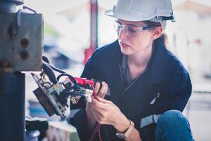 elektrisch ingenieur werk tester meten Spanning en stroom van macht elektrisch lijn in elektrisch kabinet controle voor industrieel productie. foto