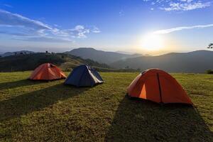 groep van avonturier tenten gedurende 's nachts camping plaats Bij de mooi toneel- zonsondergang visie punt over- laag van berg voor buitenshuis avontuur vakantie reizen foto