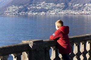 een jongen op zoek uit over- de water foto