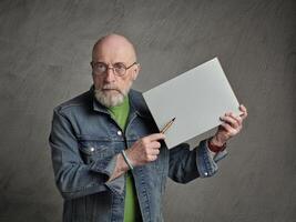 senior Mens is Holding een blanco vel van papier en een pen, presentatie concept foto