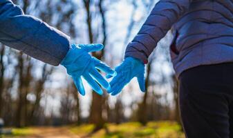 moeder s en zoon s handen in rubber medisch handschoenen. ouderlijk relaties tussen mensen. bescherming, isolatie en afstand gedurende de covid-19 coronavirus pandemie. foto