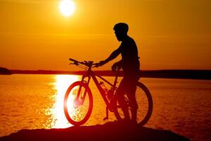 schaduw achter de zon van wielersport Mens. silhouet van ras fietser. foto