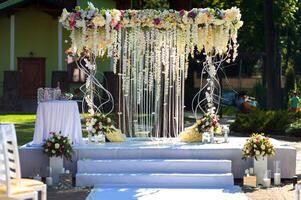 boog voor de bruiloft ceremonie. boog versierd met peachy en zilverachtig kleding en bloemen. foto