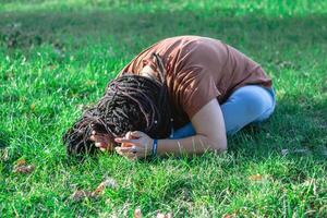 jong vrouw met lang Afrikaanse vlechtjes is aan het doen yoga buiten in een park. concept van gezond levensstijl. foto