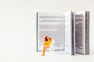 wereld boek dag concept, miniatuur mensen een jong vrouw lezing een boek alleen foto