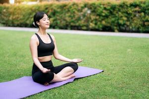 yoga harmonie, jong Aziatisch Jaren 30 vrouw vondsten kalmte in groen paradijs, beoefenen asana's en meditatie temidden van van de natuur schoonheid. foto