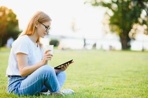 portret van jong mooi glimlachen vrouw met tablet pc, buitenshuis foto