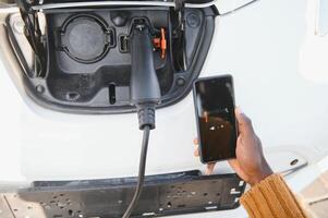 smartphone app shows opladen toestand van de elektrisch auto accu. elektro vervoer concept foto