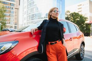 dichtbij omhoog portret van een elegant jong vrouw poseren in de buurt de auto foto