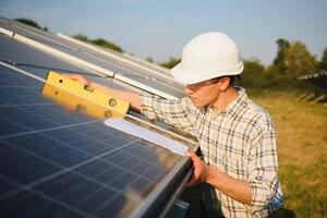 hernieuwbaar energie en zonne- macht concept, arbeider of elektrisch ingenieurs zijn controle en opleiding installeren fotovoltaïsche fabriek in zonne- macht station alternatief energie van natuur foto