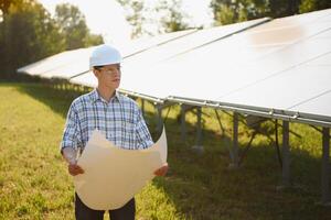 zonne- macht fabriek. Mens staand in de buurt zonne- panelen. hernieuwbaar energie. foto