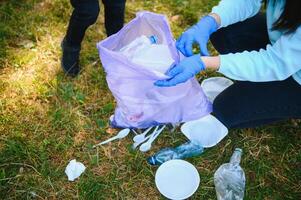 glimlachen jongen plukken omhoog uitschot in de park met zijn moeder. vrijwilliger concept. foto