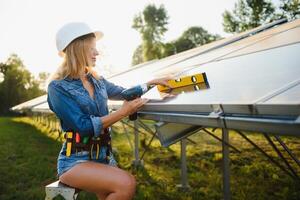 Dames ingenieur werken Aan controle uitrusting Bij groen energie zonne- macht fabriek controle zonne- paneel en structuur met tablet checklist foto