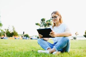 portret van jong mooi glimlachen vrouw met tablet pc, buitenshuis foto