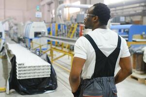 portret van industrieel ingenieur. fabriek arbeider staand in fabriek productie lijn foto