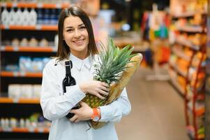 vrouw kruidenier boodschappen doen en op zoek heel gelukkig foto