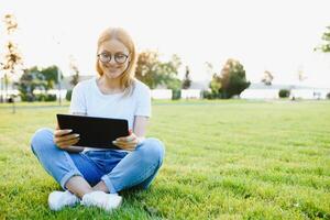 portret van jong mooi glimlachen vrouw met tablet pc, buitenshuis foto