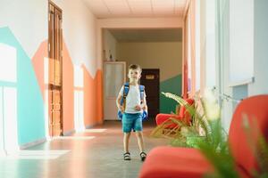 portret van een schooljongen staand met een rugzak Aan een leeg school- gang. terug naar school. foto