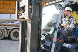 Mens arbeider Bij heftruck bestuurder gelukkig werken in industrie fabriek logistiek schip foto