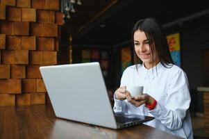 bedrijf ondernemer meisje werken online Aan laptop in cafe. foto