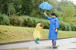 moeder met zoon wandelen in de regen onder de paraplu foto