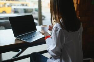 foto portret van prachtig aantrekkelijk vrouw werken Aan laptop typen zittend in cafe drinken koffie