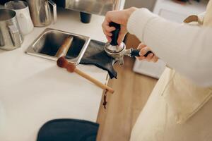 detailopname van barista maken koffie met handleiding persen gebruik makend van knoeien Bij de koffie winkel foto