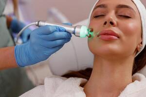 detailopname van jong vrouw krijgen esthetisch huid behandeling in schoonheid spa salon foto