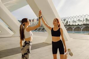 sportief Dames groet samen buitenshuis aan het doen gebaar van schudden hand- na oefenen foto