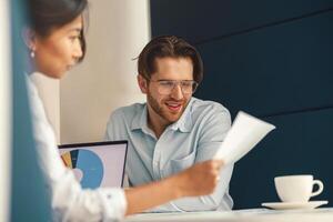 twee bedrijf collega's werken met documenten samen zittend in kantoor. samenspel concept foto