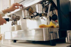 dichtbij omhoog van vrouw barista maken koffie in een koffie machine terwijl werken in cafe foto