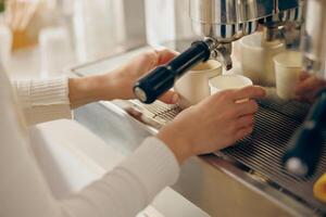 dichtbij omhoog van barista gebruik koffie machine vulling een twee cups met espresso in professioneel koffie winkel foto