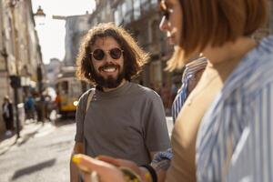 glimlachen Mens lief op zoek Aan zijn vriendin gedurende datum in oud stad straat foto
